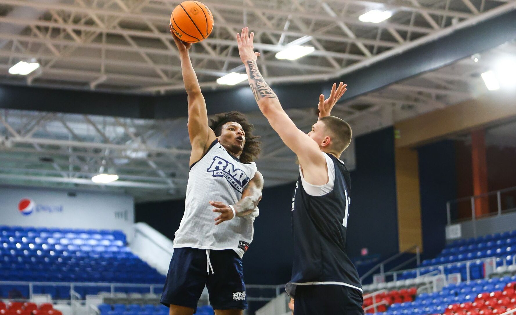 Robert Morris guard Albert Vargas shots a shot over forward Nikos Chitikoudis -- RMU Athletics