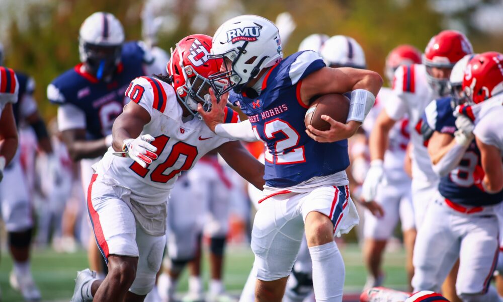 Robert Morris quarterback Jake Wolfe stiff arms a Dayton defender on Sept. 20, 2025 -- RMU Athletics