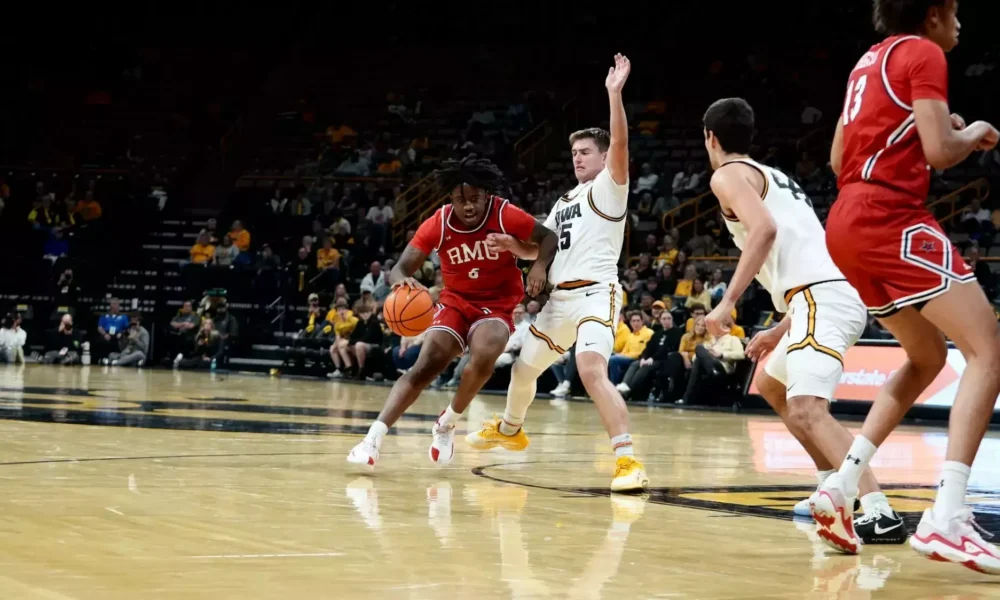 Robert Morris wing Eddie Cooke III drives against an Iowa defender -- RMU Athletics