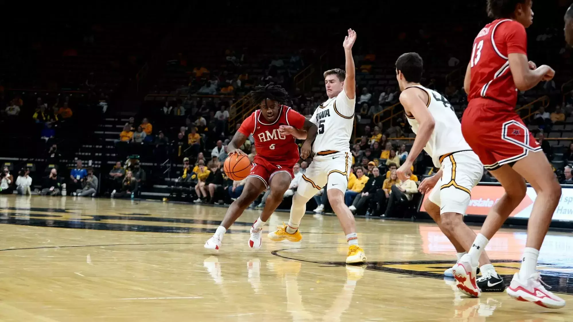 Robert Morris wing Eddie Cooke III drives against an Iowa defender -- RMU Athletics